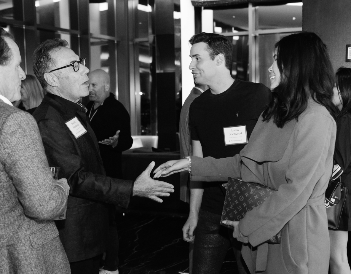 Black and white photo of people shaking hand at convention